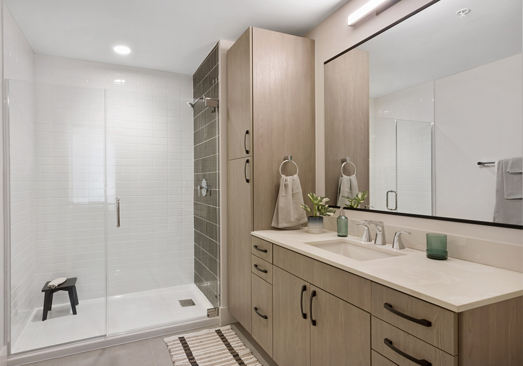Bathroom with glass-enclosed shower, white tiles, and espresso-colored cabinets